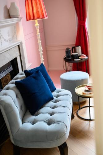 a living room with a white couch and a lamp at Queen Charlotte Guesthouse in Edinburgh