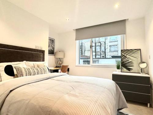 a bedroom with a large bed and a window at Modern 2 Bedroom apartment in Central London in London