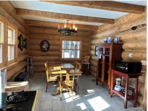 a dining room with a table in a log cabin at Moose Mtn Lodge/Luxury Cabin/Hot Tub/Fireplace in Fairplay