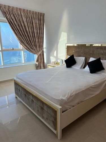 un grande letto in una camera da letto con finestra di Ft 30f R2 SeaView Room at Beach with separate bath ad Ajman