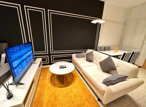 a living room with a couch and a flat screen tv at Axon Residence By Perkasa Suites in Kuala Lumpur