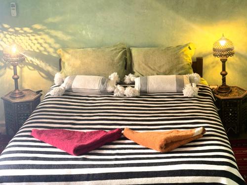 Una cama con dos almohadas y dos animales de peluche. en Riad Essaoussan en Marrakech