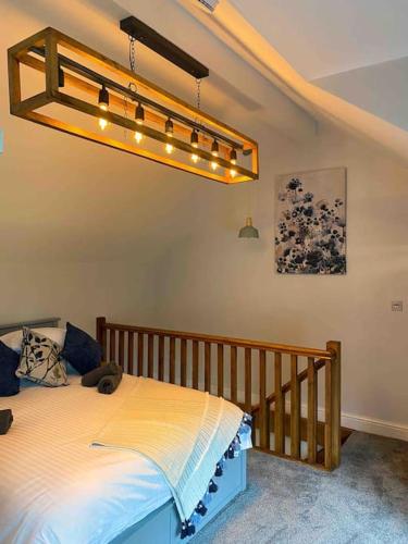 een slaapkamer met een bed met een houten wieg bij Luxurious & Tranquil staycation - w/ Hot Tub! in Burneside