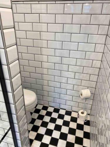 a bathroom with a toilet and a checkered floor at Luxurious & Tranquil staycation - w/ Hot Tub! in Burneside
