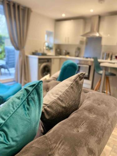 a couch with pillows sitting in a living room at Luxurious & Tranquil staycation - w/ Hot Tub! in Burneside