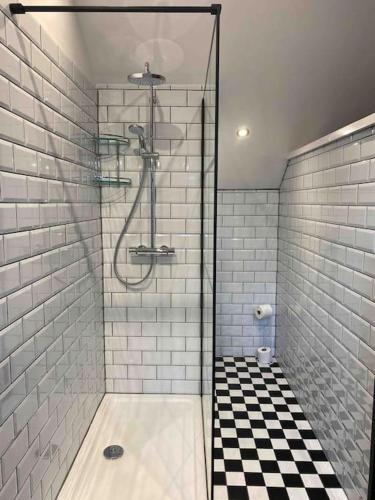 bagno con doccia e pavimento a scacchi in bianco e nero di Luxurious & Tranquil staycation - w/ Hot Tub! a Burneside