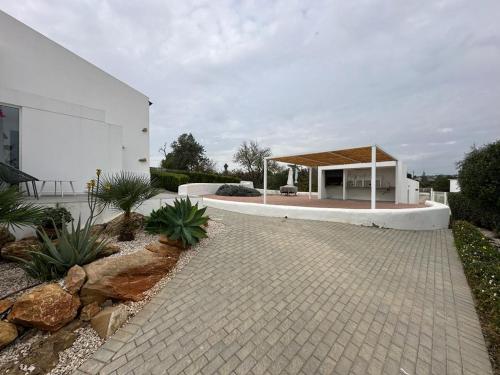 a white house with a pavilion and a patio at Casa Monte dos Entrudos in Almancil
