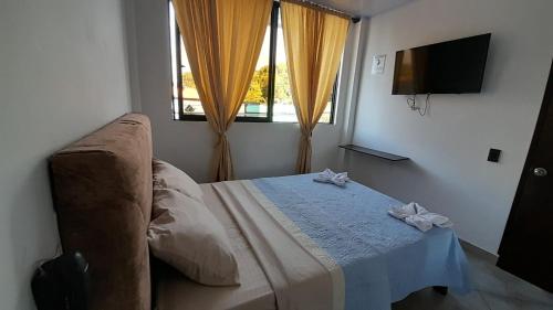 a bedroom with a bed with a table and a window at Katara Boutique Hotel in Mariquita