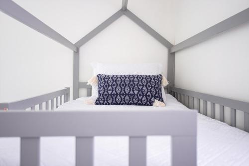 een wit bed met een blauw kussen in een kamer bij Corner Casa (w Bikes!) Beach Home (3bd/2ba) in Jacksonville Beach