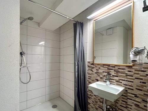 a bathroom with a shower and a sink and a mirror at Ferienapartment Eva - gemütlich und zentral auf der historischen Insel Lindau in Lindau