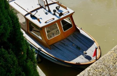 a boat sitting in the water next to a wall at Villa Napoléon Piscine&Jacuzzi in Le Somail