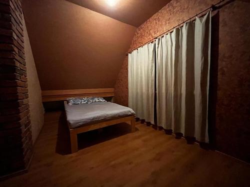 a small room with a bed and a window at Pirts māja Lilijas in Baldone