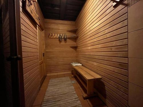 a sauna with a bench in a wooden wall at Pirts māja Lilijas in Baldone