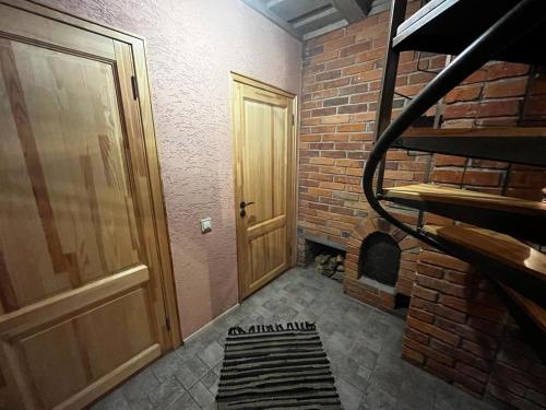 a brick room with a door and a brick fireplace at Pirts māja Lilijas in Baldone