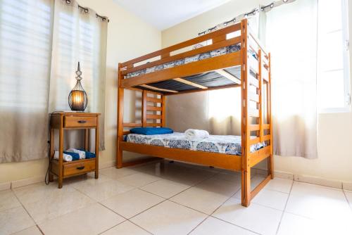 a bedroom with two bunk beds and a night stand at Colinas del Atlantico Vacational House 1st floor in Isabela