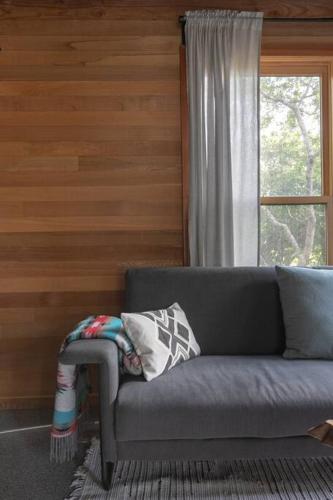 a gray couch in a room with a window at Oregon Coast Modern at Neahkahnie Beach in Nehalem