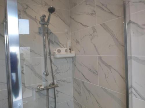 a bathroom with a shower with marble tiles at Fresher Space Home Stay in Birmingham