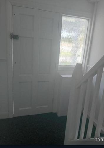 a white room with a door and a window at Fresher Space Home Stay in Birmingham