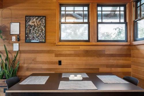 a dining room with a table and two windows at Oregon Coast Modern at Neahkahnie Beach in Nehalem