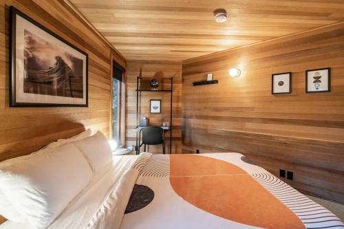 a bedroom with a bed in a room with wooden walls at Oregon Coast Modern at Neahkahnie Beach in Nehalem