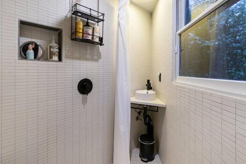 a white tiled shower with a sink and a window at Oregon Coast Modern at Neahkahnie Beach in Nehalem