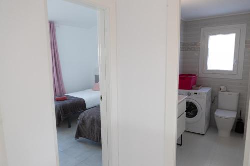 a bathroom with a toilet and a washing machine at Luna dreams in Peñíscola
