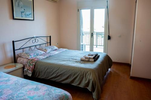 1 dormitorio con 2 camas y puerta a un balcón en Fani's Family House, en Ierápetra