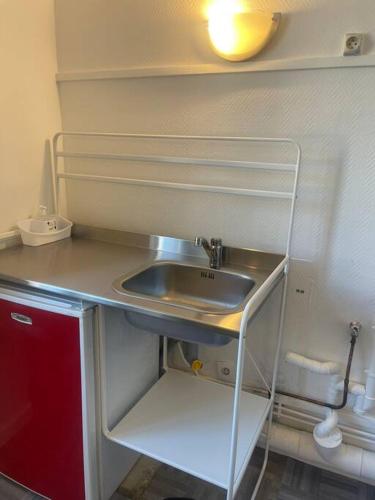 une petite cuisine avec évier et étagère. dans l'établissement Appartement Croix rousse 69004, à Lyon