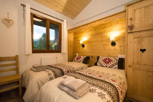 une chambre avec deux lits et une fenêtre dans l'établissement Samoëns, new apartment, 3 bedrooms, 6 persons, close to village centre and skibus, à Samoëns