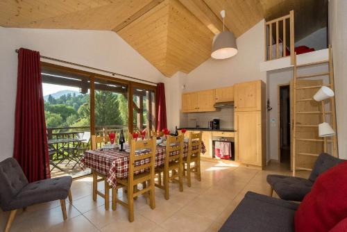 une salle à manger avec une table et une cuisine dans l'établissement Samoëns, new apartment, 3 bedrooms, 6 persons, close to village centre and skibus, à Samoëns