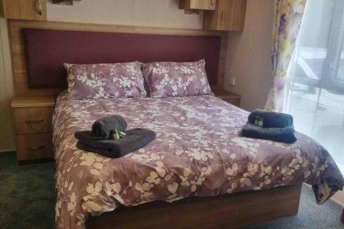 Un dormitorio con una cama con dos sombreros. en Coorie Nook, Chalet 103, en Aviemore