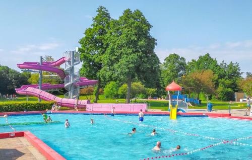 a group of people in a swimming pool with a water slide at Tiny Zen House in Heinkenszand with private sauna, airco, outdoor swimming pool, WiFi and 2 bedrooms in Heinkensand