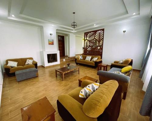 a large living room with couches and a fireplace at Riri Country Living Isinya in Kitengela 