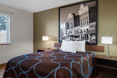 a hotel room with a bed with two lamps at Super 8 by Wyndham Livingston in Livingston