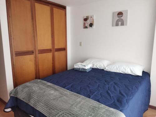 a bedroom with a bed and a wooden door at aparta-estudio INTELIGENTE norte de Tunja cristales in Tunja
