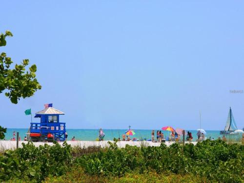 a group of people on a beach with a lighthouse at Sarasota Paradise Heated Pool Home Near IMG & Siesta Key Beach in Sarasota