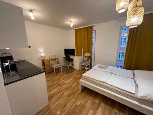 a bedroom with a bed and a kitchen and a desk at New Business Apartment Nr.15 in Dresden