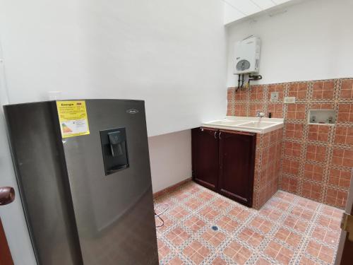 a small bathroom with a sink and a refrigerator at aparta-estudio norte de Tunja cristales in Tunja