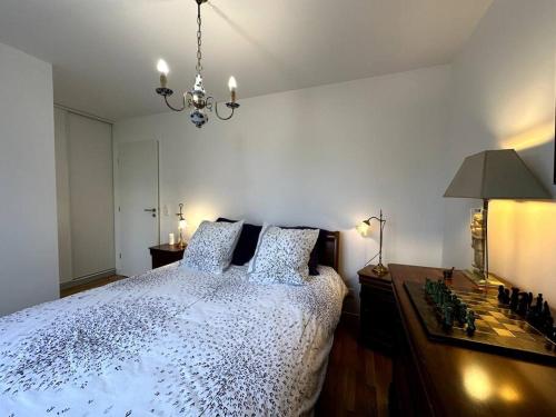 une chambre avec un grand lit et un lustre dans l'établissement Bright sunny flat 2 bedrooms 750 sqft + free PKG, à Saint-Ouen