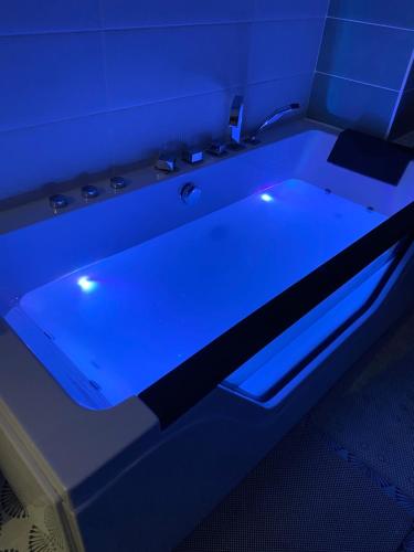 a bath tub with a blue light in a room at Au bord du gave in Laruns