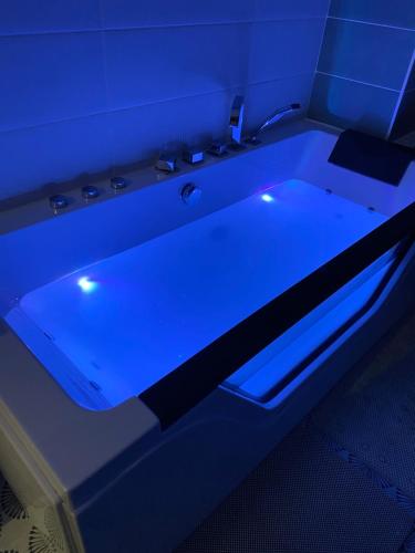 uma banheira com luz azul num quarto em Au bord du gave em Laruns