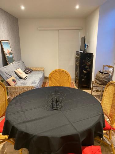 um quarto com uma mesa com uma toalha de mesa preta em Au bord du gave em Laruns