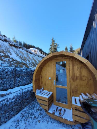 a wooden sauna with snow on the ground at Cucu Zen Cazare Cabane Pensiuni Bucovina in Iacobeni