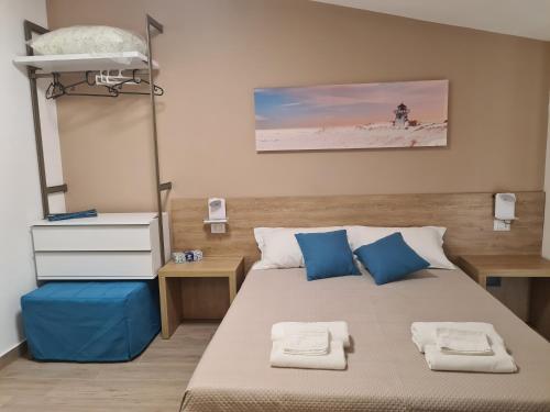 1 dormitorio con 1 cama con almohadas azules en B&B Al Quadrato, en Scalea