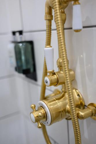 a gold faucet in a bathroom with a sink at Queen Charlotte Guesthouse in Edinburgh