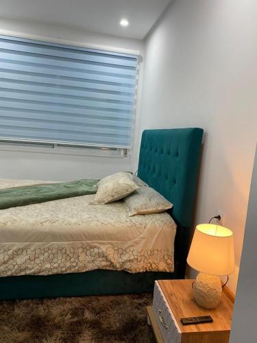 1 dormitorio con 1 cama con cabecero verde y ventana en LuxeNew, en Tánger