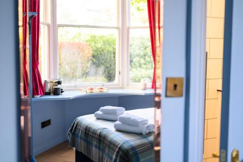 a room with a window and towels on a table at Queen Charlotte Guesthouse in Edinburgh