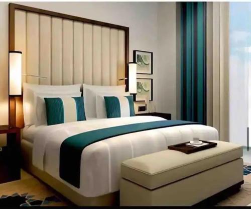 a bedroom with a large bed with a large headboard at Fairmont Marina Residences Apartment in Abu Dhabi