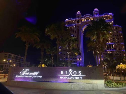 a las vegas sign in front of a building with purple lights at Fairmont Marina Residences Apartment in Abu Dhabi