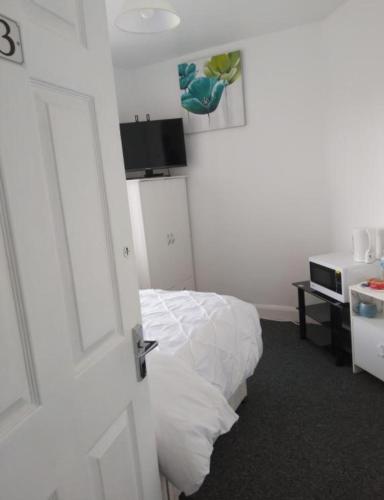 a white room with a bed and a door at Fresher Space Home Stay in Birmingham